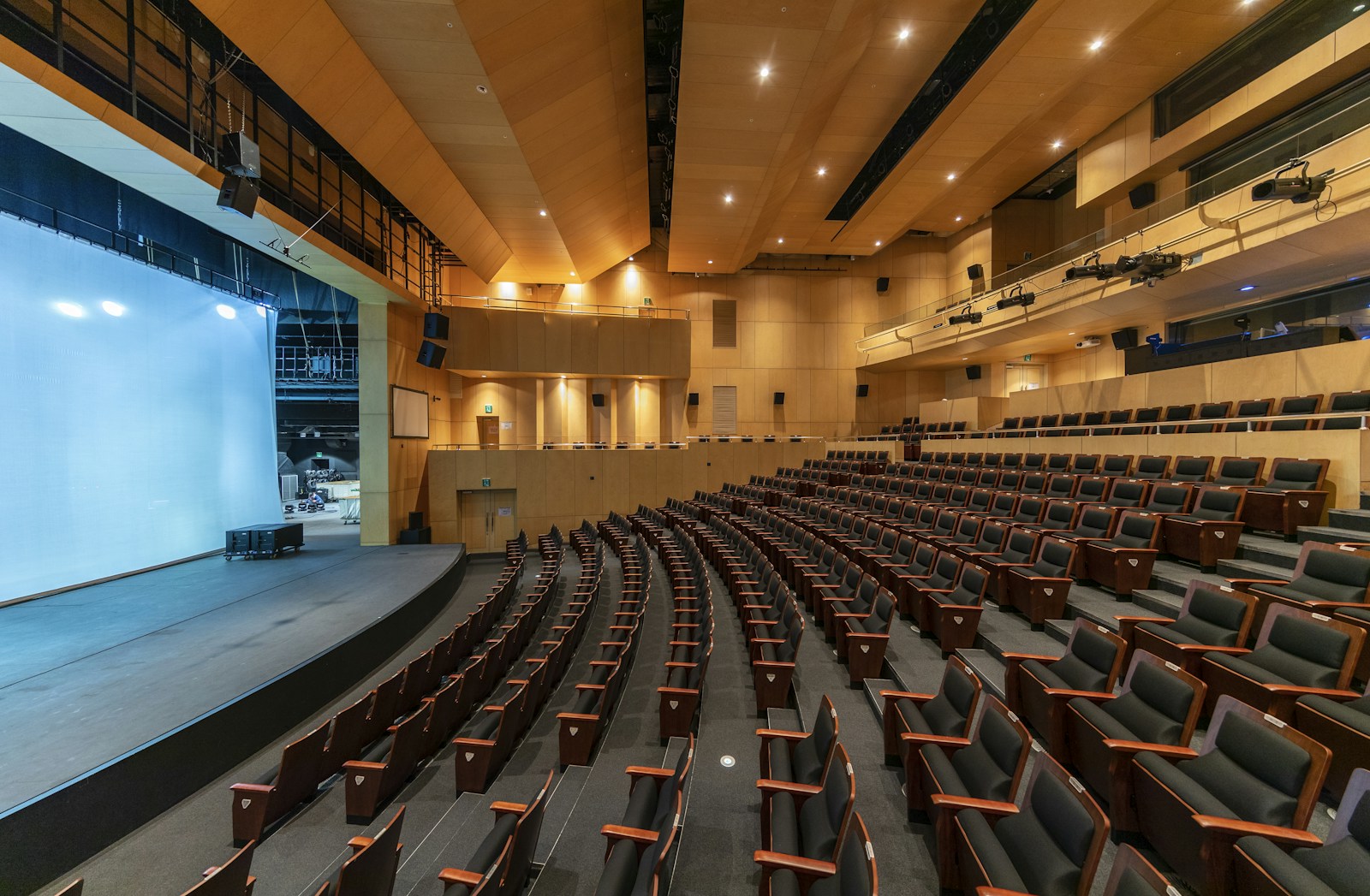 Illustrative contemporary auditorium with dark seating and warm acoustic woodwork; not HACPAC